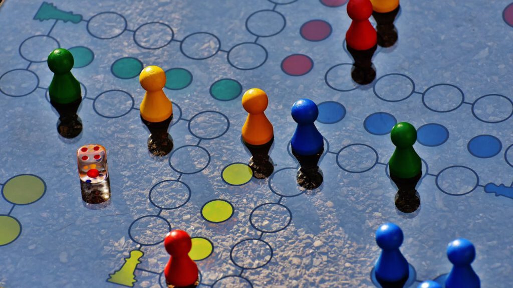 Close-up of a colorful board game with pawns and a dice, perfect for family fun.