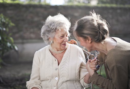 Joyful interaction between an elderly woman and her granddaughter in a sunny outdoor setting.