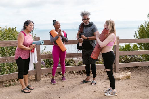 Friends enjoying yoga and laughter outdoors, embracing wellness.