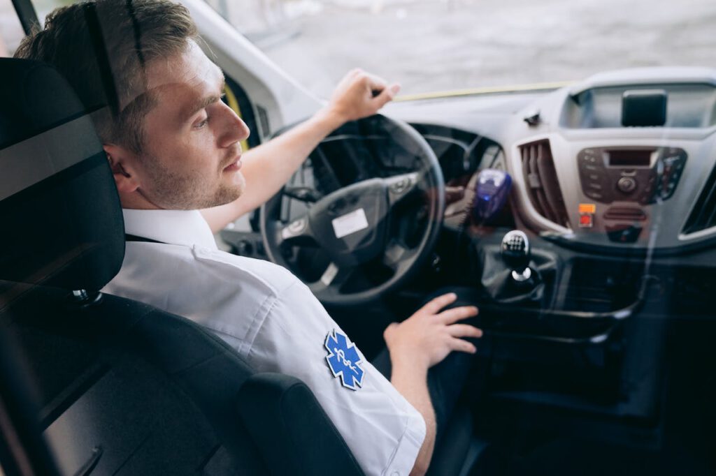 Ambulance driver focused on the road in an emergency vehicle, showcasing urgency and professionalism.